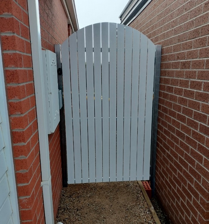 White arched pedestrian gate with steel posts and frame